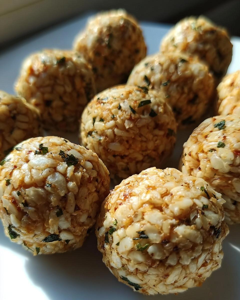 Close-up of several Amazing Chicken & Rice Energy Bites for dogs, made with visible rice and herbs.