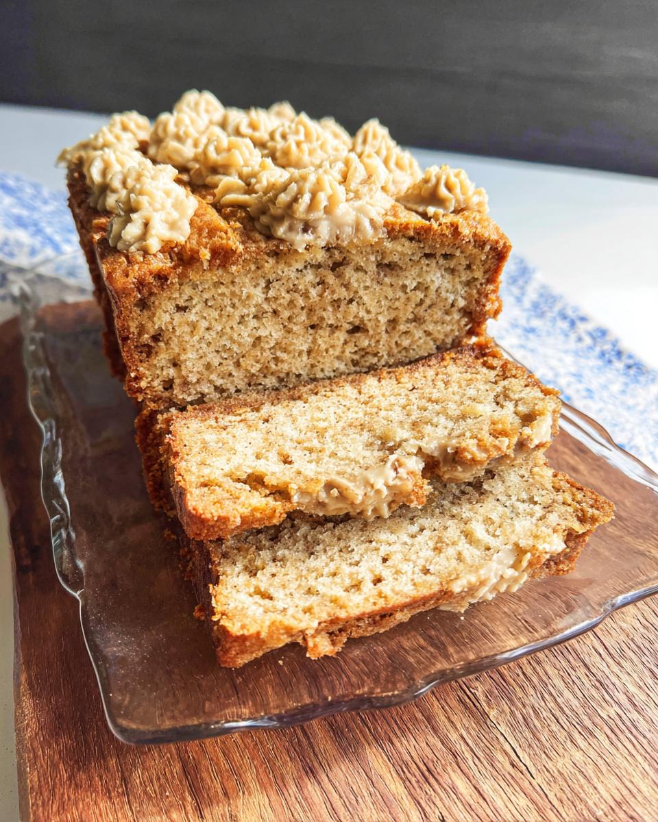 Slices of Soft PB Banana Dog Loaf Cake topped with piped peanut butter frosting.
